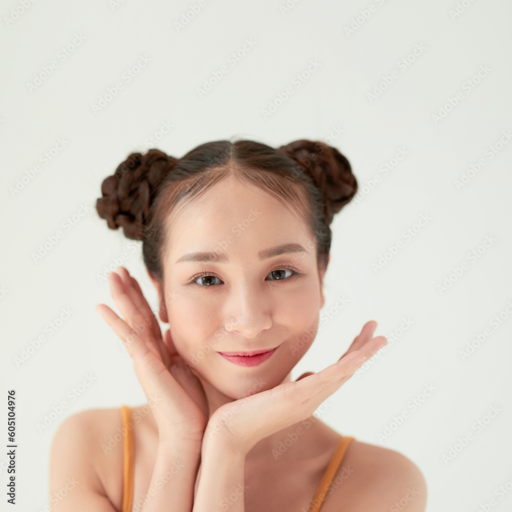 Wall mural modern playful girl with two hair buns smiling looking up dreamily.