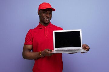 american service employee man in red cap and t-shirt holding laptop with mockup