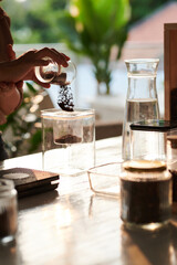 Barista putting ground coffee in cold brew coffee maker