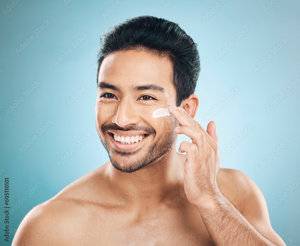 Sticker Skincare, beauty and man with face cream in a studio for a natural, wellness and health routine. Happy male model with facial spf, lotion or moisturizer for dermatology treatment by a blue background