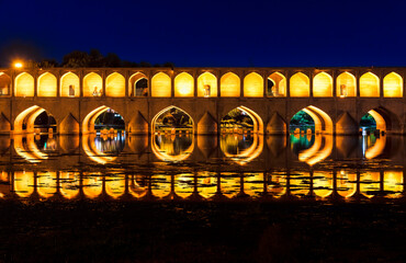 Si-o-Se Pol (Bridge of 33 Arches or Allahverdi Khan Bridge) at night on Zayanderud River in Isfahan, Iran. Architectural masterpiece and historical heritage. Tourist destination.