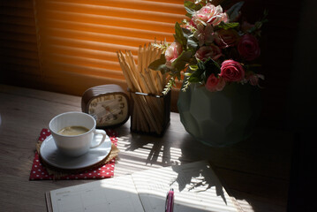 Agenda, planner book, calendar, cup of coffee, pencil, and clock placed on business office desk in morning. Diary for organizer to plan timetable, daily appointment, and management job in work room.