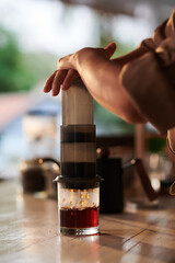 Barista using aeropress when making cup of coffee for customer