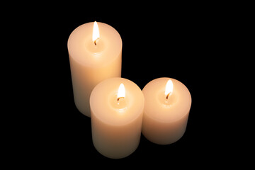 Top view of white burning candles on black background.