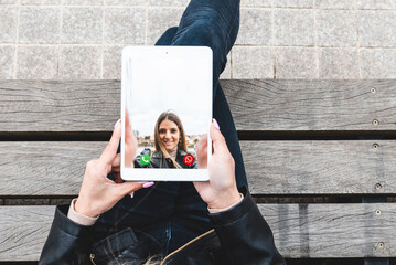 A young girlfriends talking to each other via online video chat.The girl is holding a pc tablet...