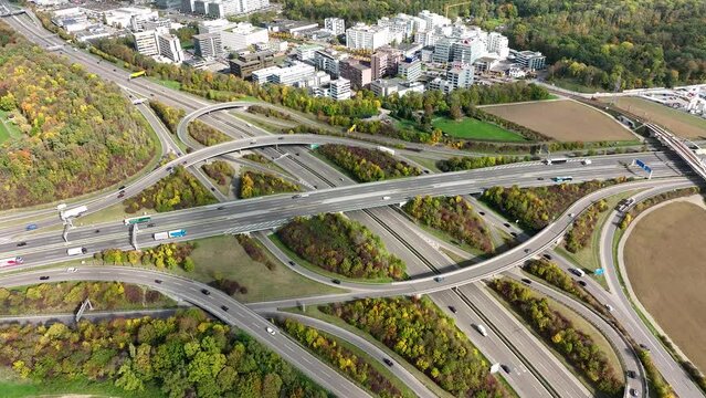 Aerial drone view of a multi-level highway intersection with moving cars near the city of Stuttgart, Germany. Trucks move along a multi-level road junction. The concept of the urban.