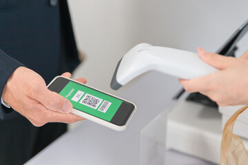 コンビニ・スーパーでQRコード決済するビジネスマン
