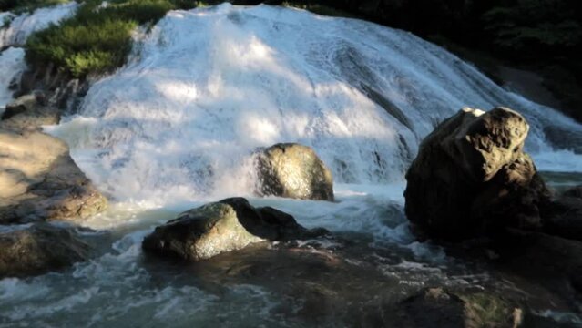 hermosa cascada blanca con mucha agua fluyendo y vegetaci&oacute;n verde alrededor.