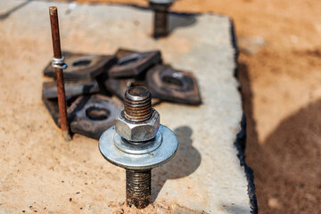 Close up the anchor bolts in concrete base of new edifice with reinforcement at building site.