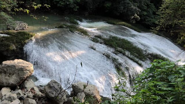 hermosa cascada blanca con mucha agua fluyendo y vegetaci&oacute;n verde alrededor vista desde un &aacute;ngulo superior.