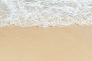 Fototapeta na wymiar Soft wave of sea on empty sandy beach Background with copy space..