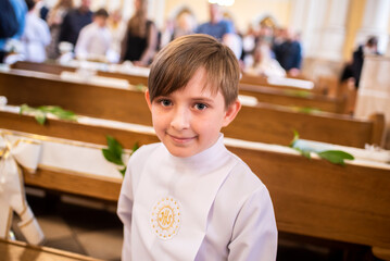 Fototapeta na wymiar boy before first Eucharist in a catholic church. child in white clothes in the church