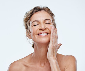 Skincare, smile and a woman with an anti aging cream isolated on a white background in a studio....
