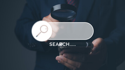 Businessman using magnifying glass search browsing for information by phone.