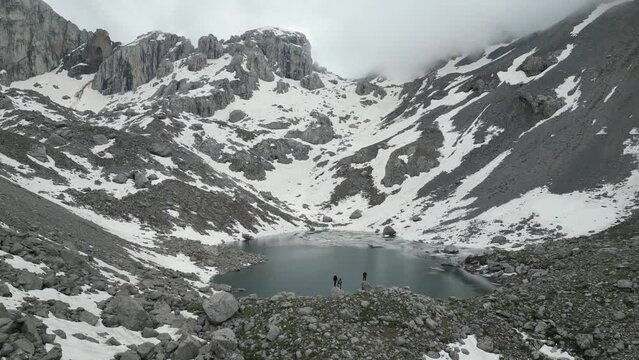 team of mountaineers exploring the glacial lake at the top of the mountains