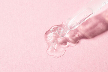 Obraz na płótnie Canvas Pipette dropper and liquid smear with bubbles on pink background. Serum, collagen, enzyme, peptides,hyaluronic acid swatch,