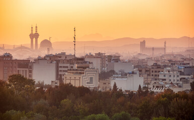 Cityscape and skyline of historical city of Isfahan at sunrise with minarets and domes, mountains on background, Isfahan, Iran. First tourist destination in Iran.