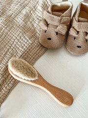 a beige muslin scarf, brown shoes with a muzzle and ears and a children's hair brush lie on a light background