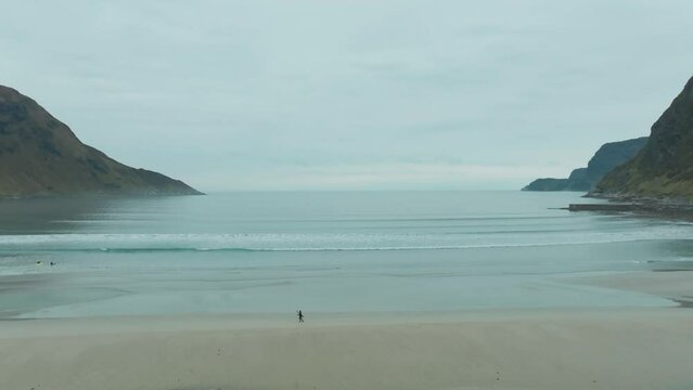 Surfer running on beach in Hoddevik Norway