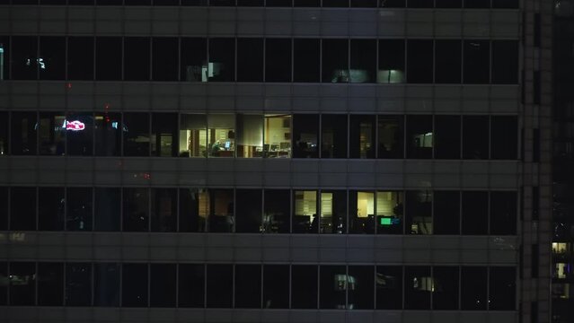 Man working alone in the office at night, empty offices in skyscraper