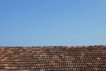 old roof tiles on top of roof against clear blue sky with space for text in Bibinje, Croatia