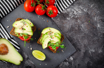 Avocado Toasts with Tomato, Healthy Snack or Breakfast on Dark Background