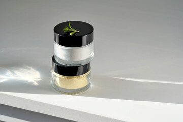 Two closed jars of enzime face scrub.