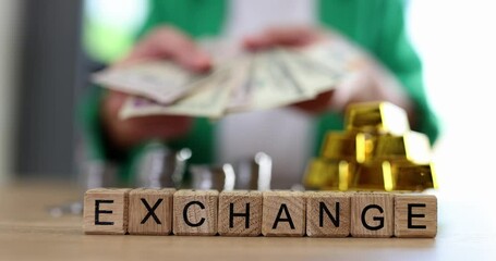 Word of wooden cubes with words interchange of gold bars with coins and with dollars. Buying and selling financial assets