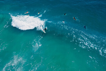 Surfer on surfboard ride on wave in blue ocean. Aerial view