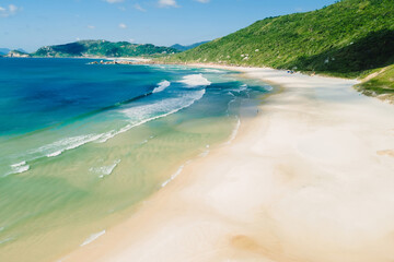 Sandy beach with mountains and ocean with waves in Brazil. Aerial view of Praia da Galheta