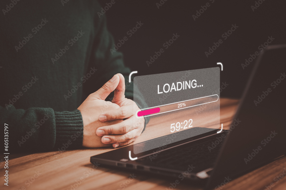 Poster Young user using a laptop computer for download and update software with waiting to loading digital file data form website, very slow internet form wifi. Concept of waiting for load of loading symbol.