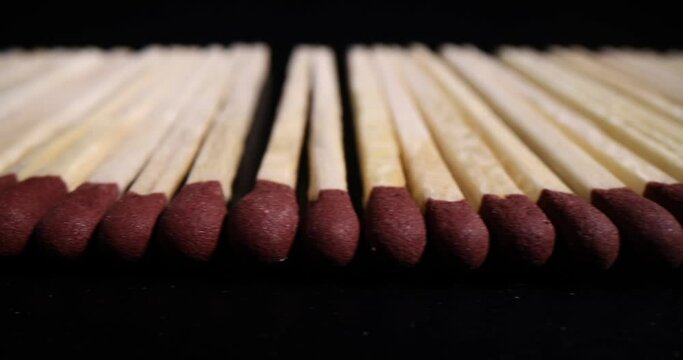 Matches with brown heads are arranged in row. Wooden matches for making a fire on a dark background