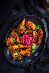 Grilled Lemon and garlic chicken wings with pickled root vegetables and jalapenos. Asia style cuisine.