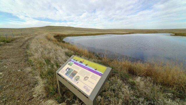Pan of lake and interpretive sign on trail