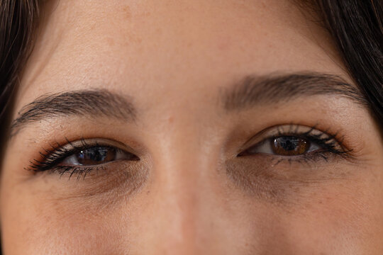 Portrait close up of brown eyes of happy caucasian female customer at hair salon
