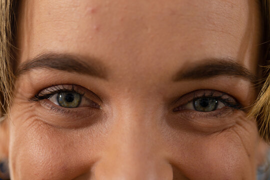 Portrait close up of caucasian female hairdresser with blue eyes smiling