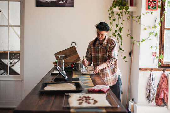 person baking at home with trays for oven mixes from online recipe
