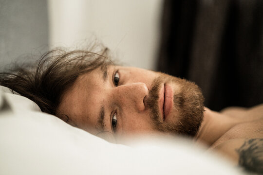 Handsome man in bed after sleep wakes up and starts a new day.