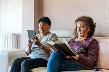two old women reading with electronic book and paper book