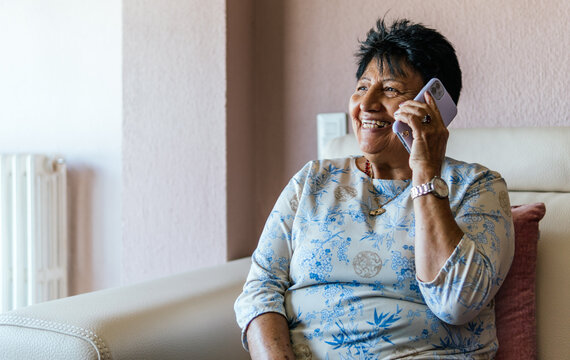 latin american senior woman talking with her friends on the smartphone