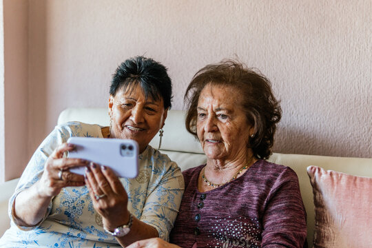 two elderly women with the smartphone taking a photo of themselves