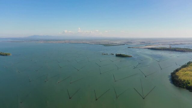 Aerial drone of Fish farm with cages for fish and shrimp. Fish ponds for bangus, milkfish. Farming aquaculture or pisciculture practices. Philippines, Luzon.