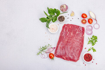 Dry aged Bavette steak with traditional spices and herbs. Fresh raw meat cut, light stone background