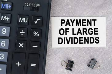 On a gray surface lies a calculator, a pen and a business card with the inscription - payment of...