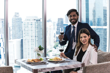 Fototapeta premium Indian man and Asian woman drinking wine celebratation onrooftop bar and restaurant, Dinning Rooftop