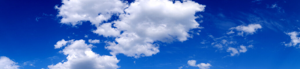 Naklejka na ściany i meble Blue sky background with white clouds. Cumulus white clouds. Panoramic image