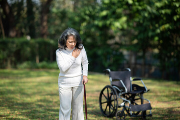 Asian old woman sitting on a wheelchair outdoors in the garden There is pain in the heart