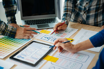  UX developer and ui designer brainstorming about mobile app interface wireframe design with...