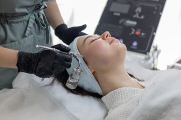 Pretty girl getting oxygen face therapy in beauty salon. Professional skin care treatment. Unique technology of non-injection oxygen mesotherapy, innovative technique without any painful sensations.