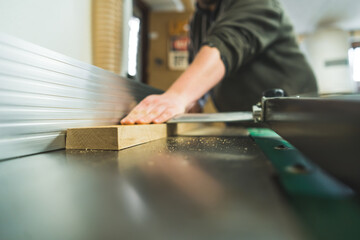 carpenter using a table saw while working in his woodworking studio, extreme closeup shot. High quality photo